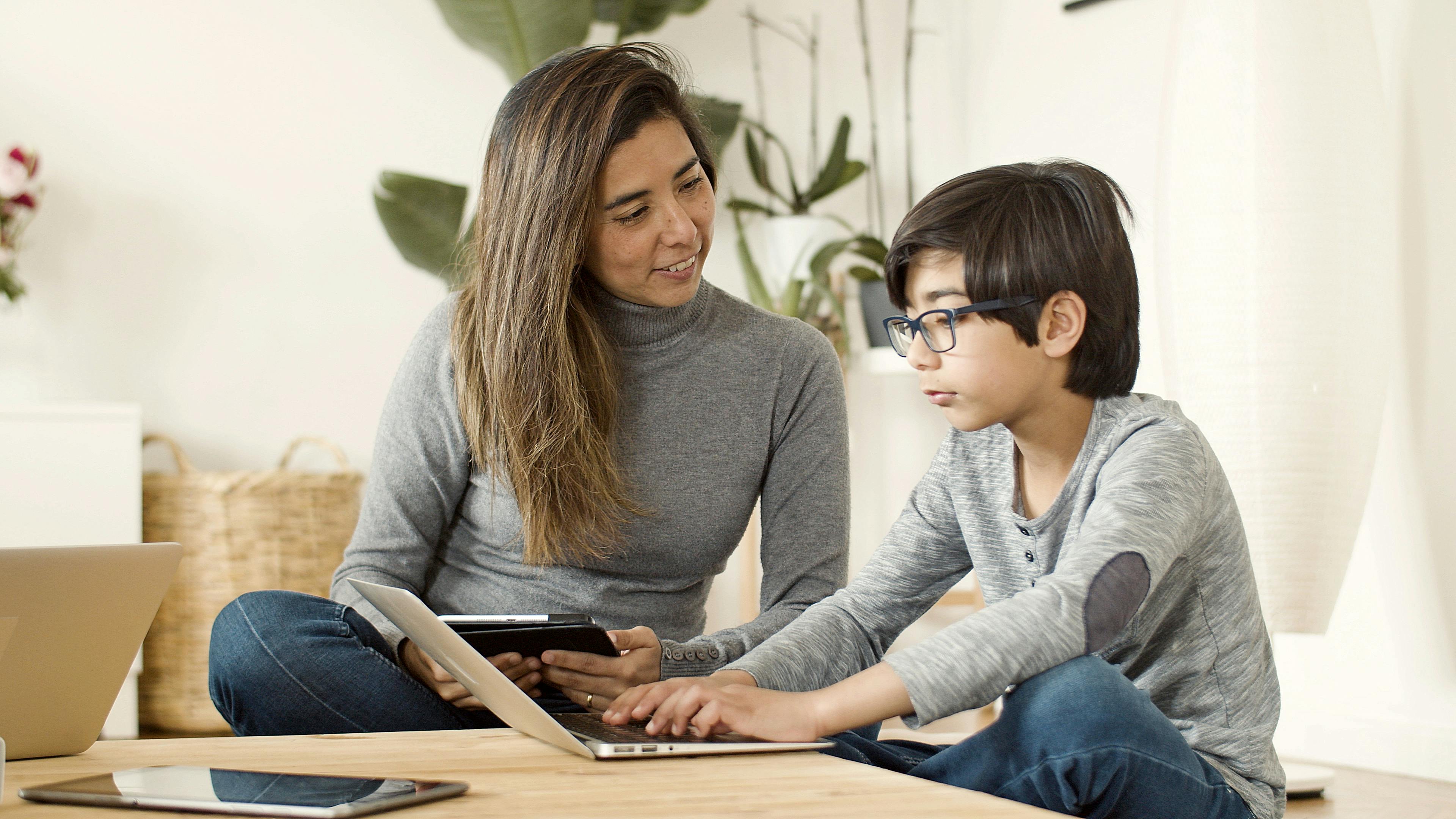 boy using laptop beside a woman