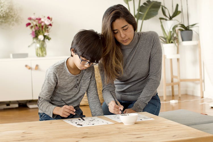 A Boy And Her Mother Drawing Together