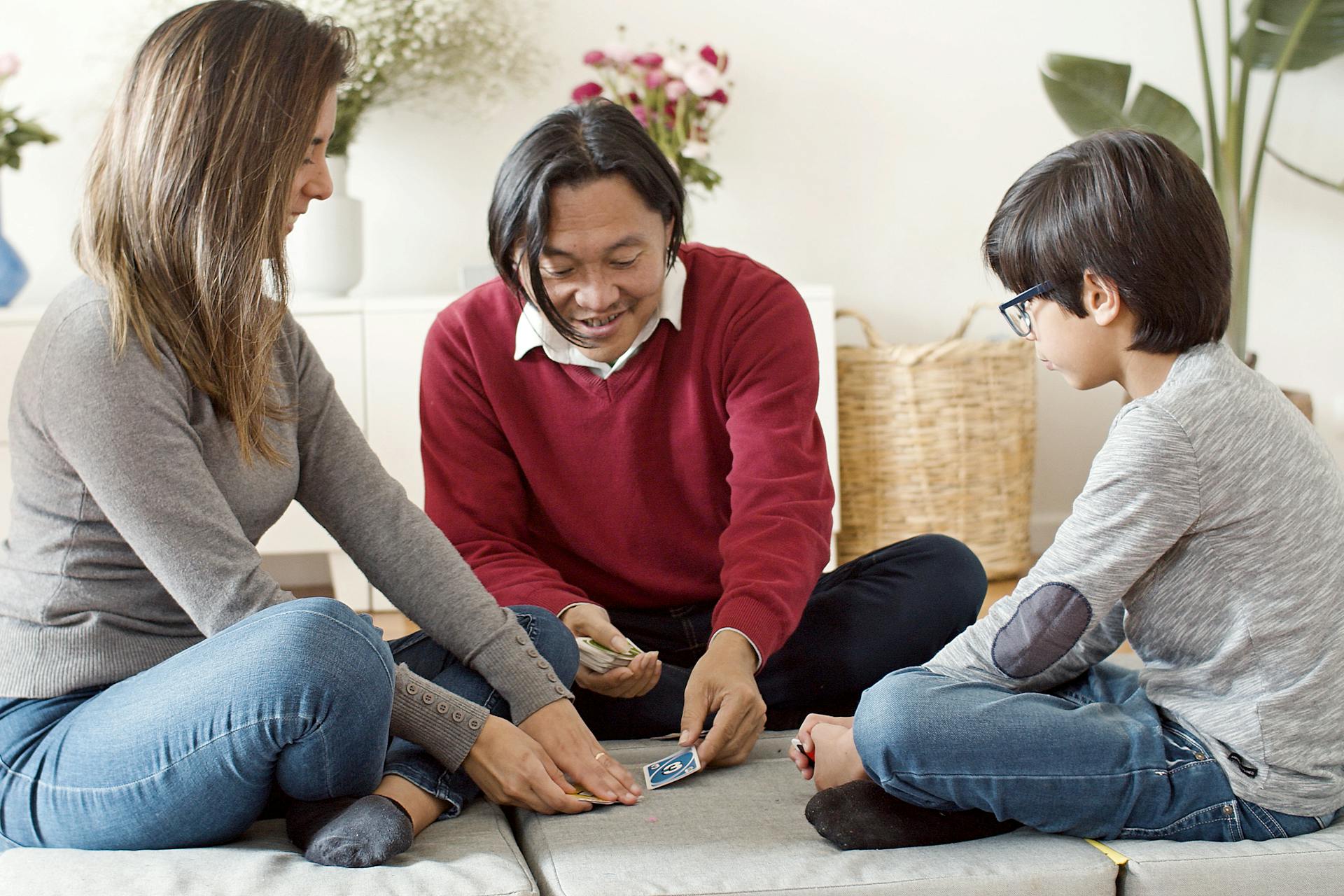 A family having fun playing a card game in their living room, creating joyful memories.