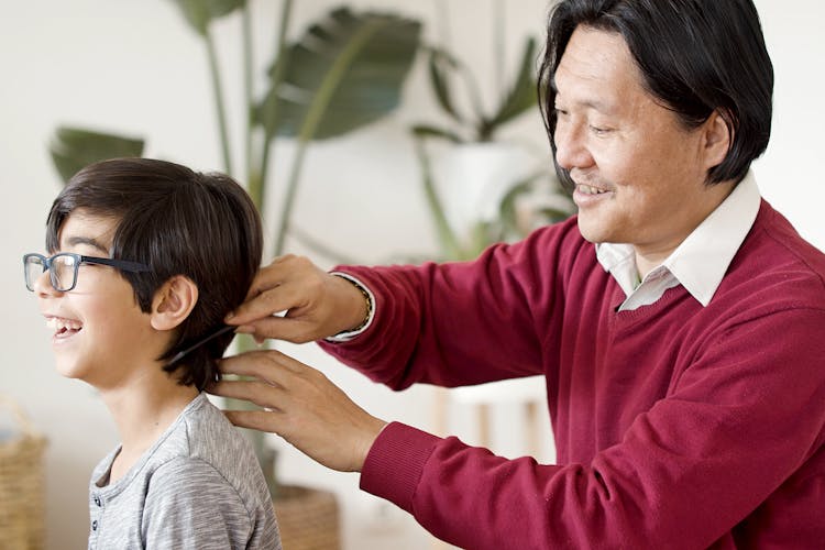 Man Combing The Hair Of A Boy