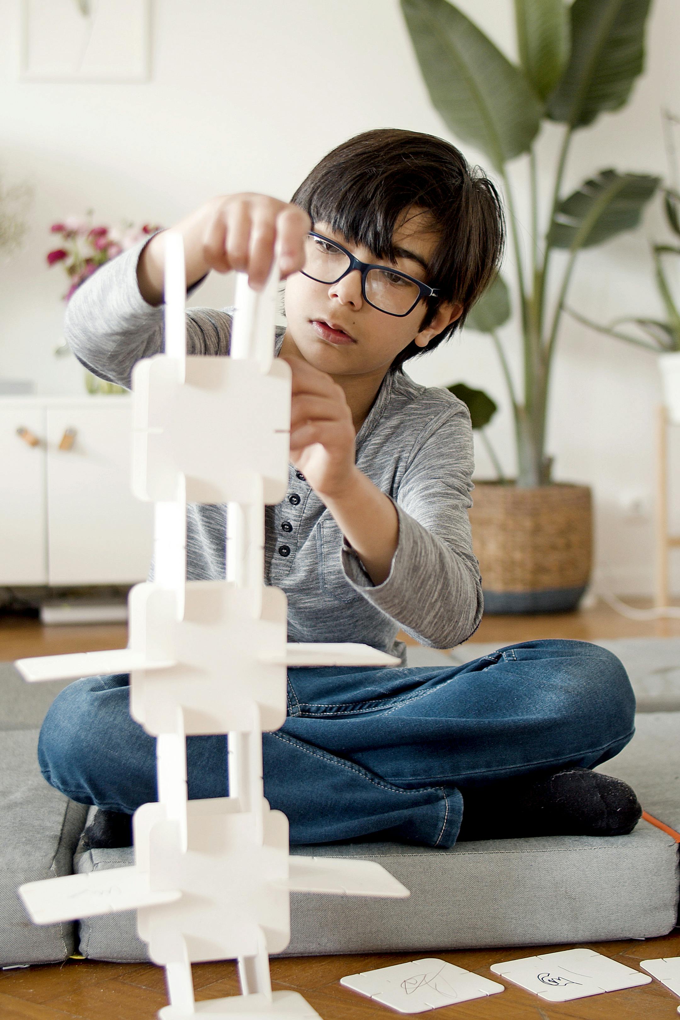 a boy making paper tower