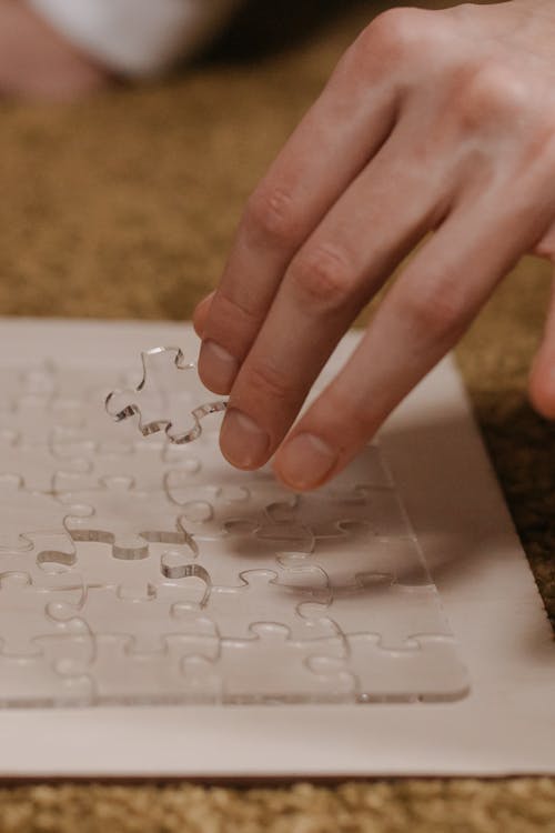 

A Close-Up Shot of a Person Doing a Transparent Puzzle