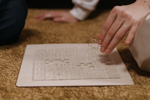 
A Close-Up Shot of a Person Doing a Transparent Puzzle