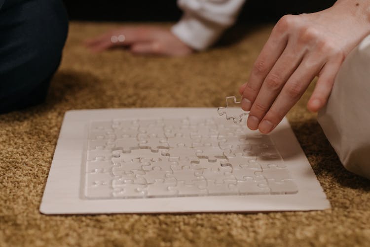 
A Close-Up Shot Of A Person Doing A Transparent Puzzle