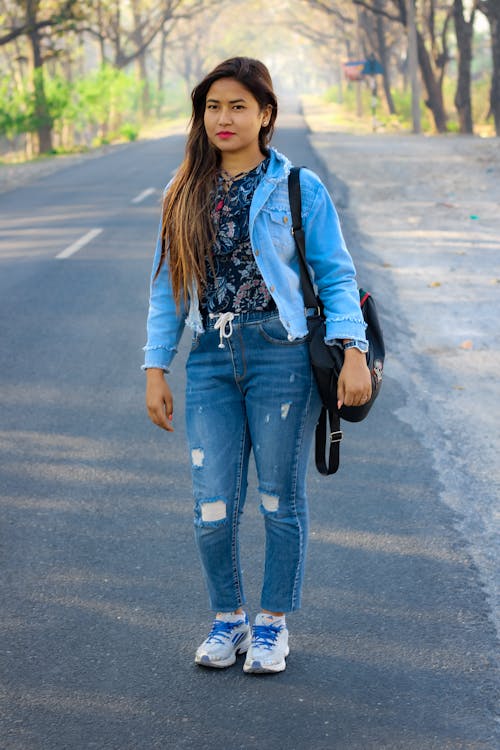 Woman Wearing Denim Jacket Standing on the Road