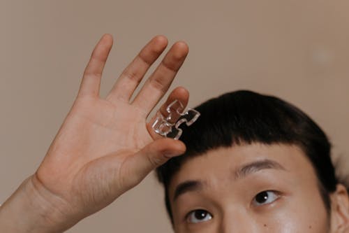 A Person Holding a Piece of Glass Puzzle 