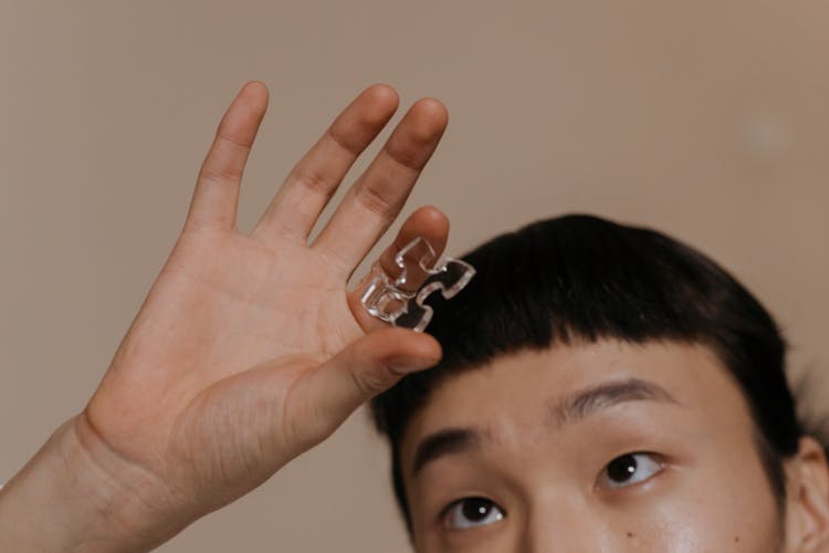 A Person Holding A Piece Of Glass Puzzle 