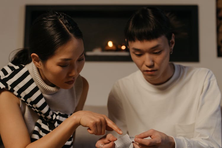 A Woman Pointing At A Fabric On A Man's Hand