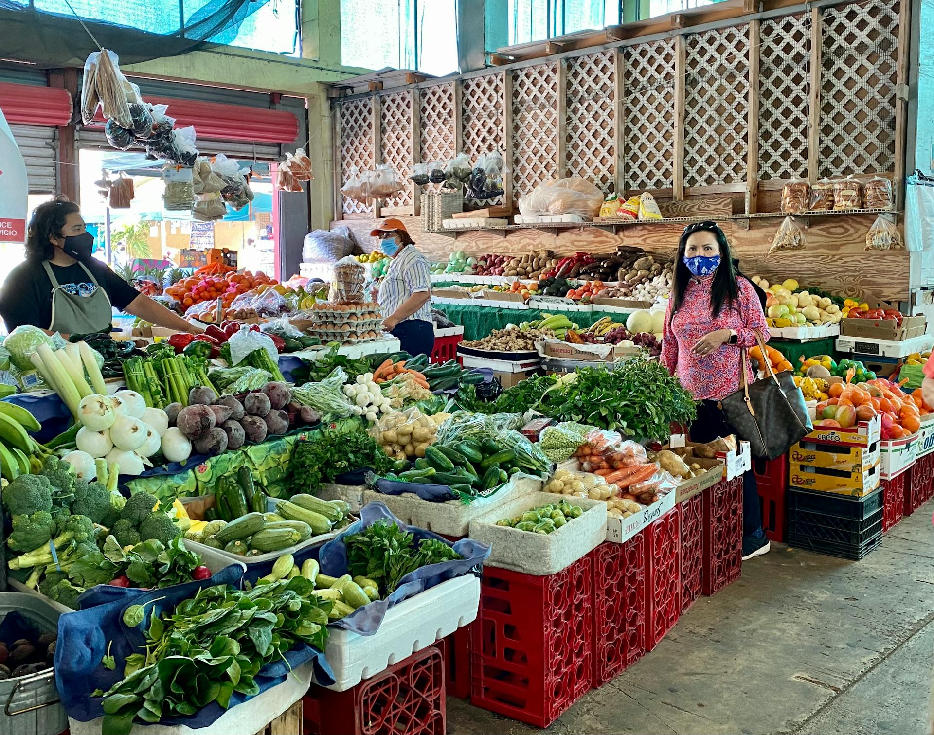 Colorful market scene in Florida City with fresh produce and masked shoppers.