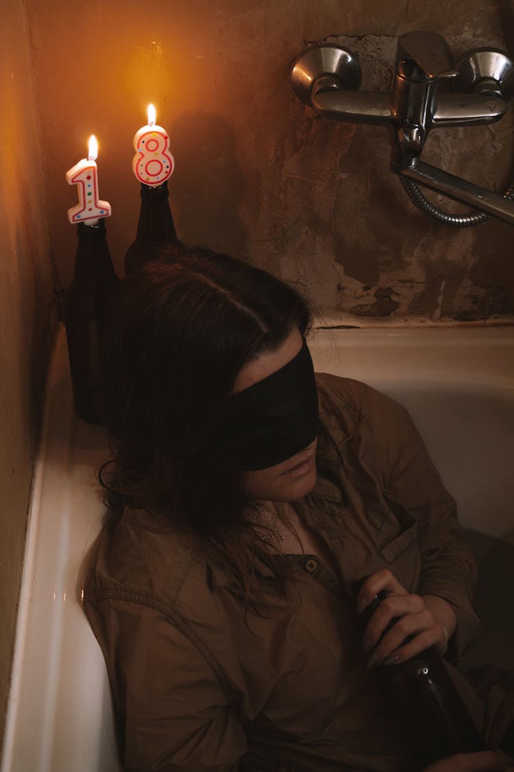 Blindfolded Woman Sitting In A Bathtub