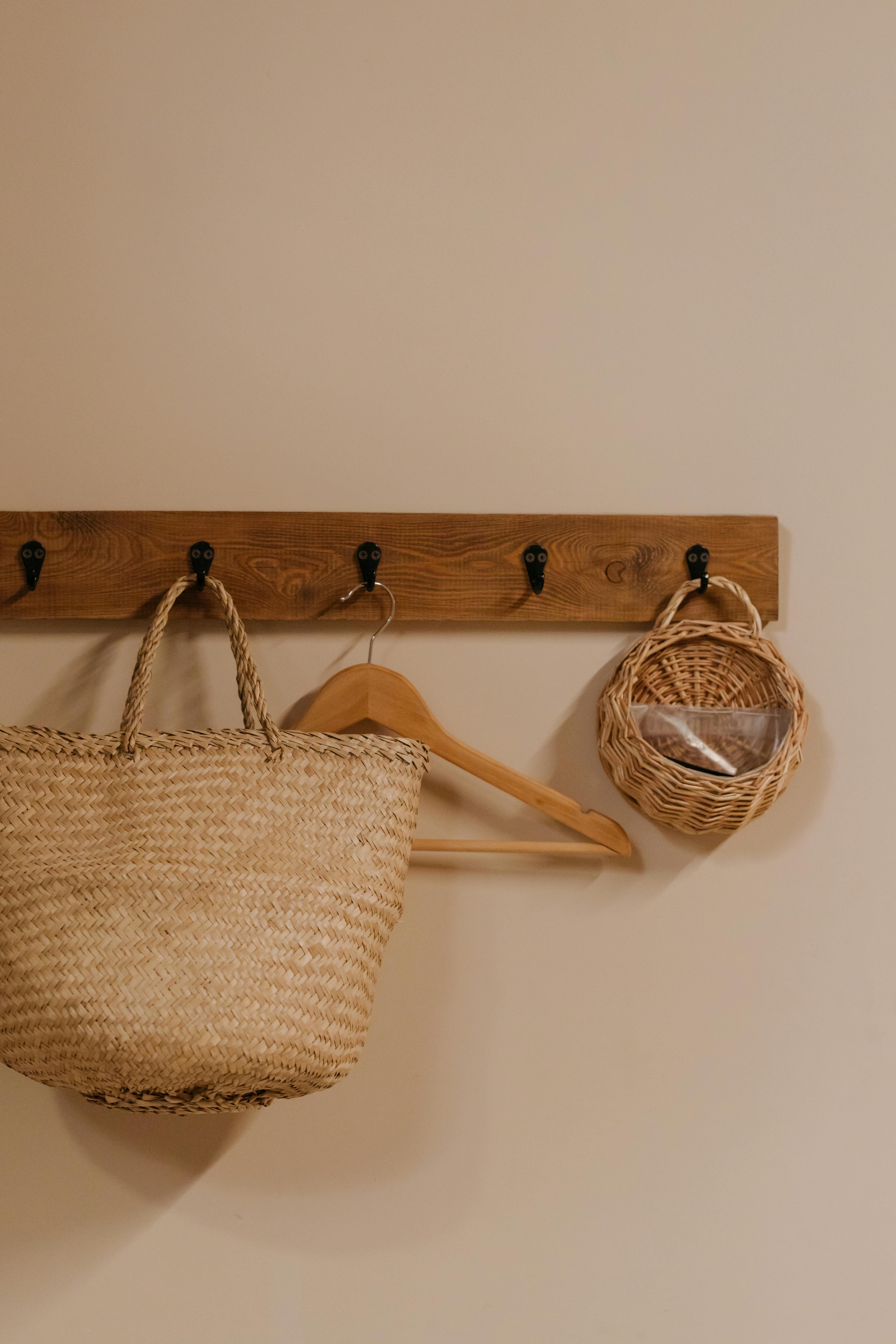 brown woven tote bag hanged on beige wall