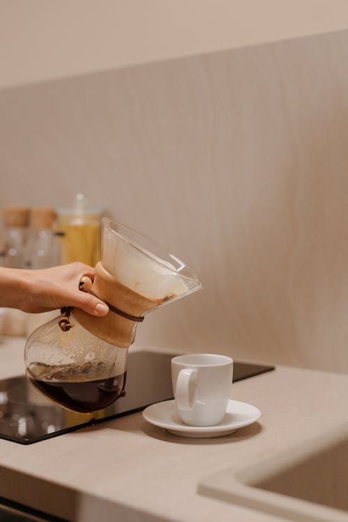 Person Pouring Coffee in Cup