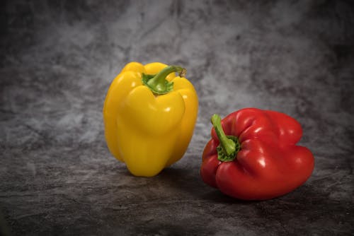 Free Yellow and Red Bell Peppers on Gray Surface Stock Photo