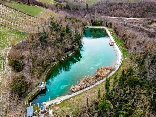 Free Aerial shot of a tranquil forest pond surrounded by autumn foliage, captured from above. Stock Photo