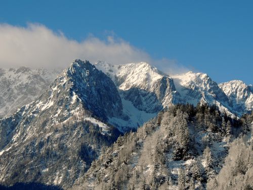 Free Dramatic snow-covered mountains under a clear blue sky, capturing winter's serene beauty in the Alps. Stock Photo