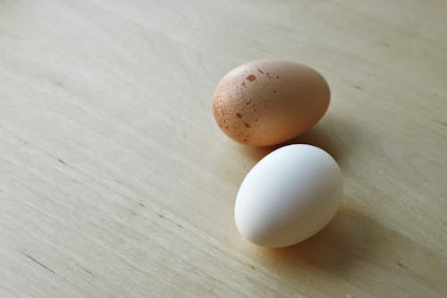 Brown and White Egg on Wooden Surface