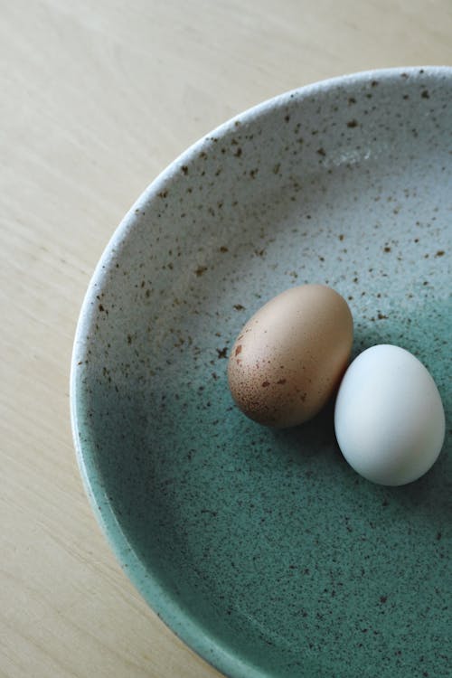 Brown and White Eggs on Blue Ceramic Bowl