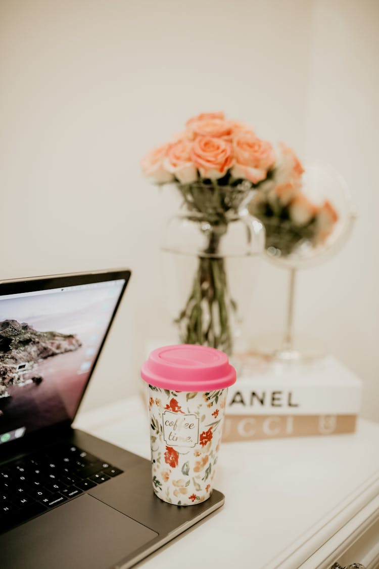 Pink And White Floral Tumbler On A Macbook Pro