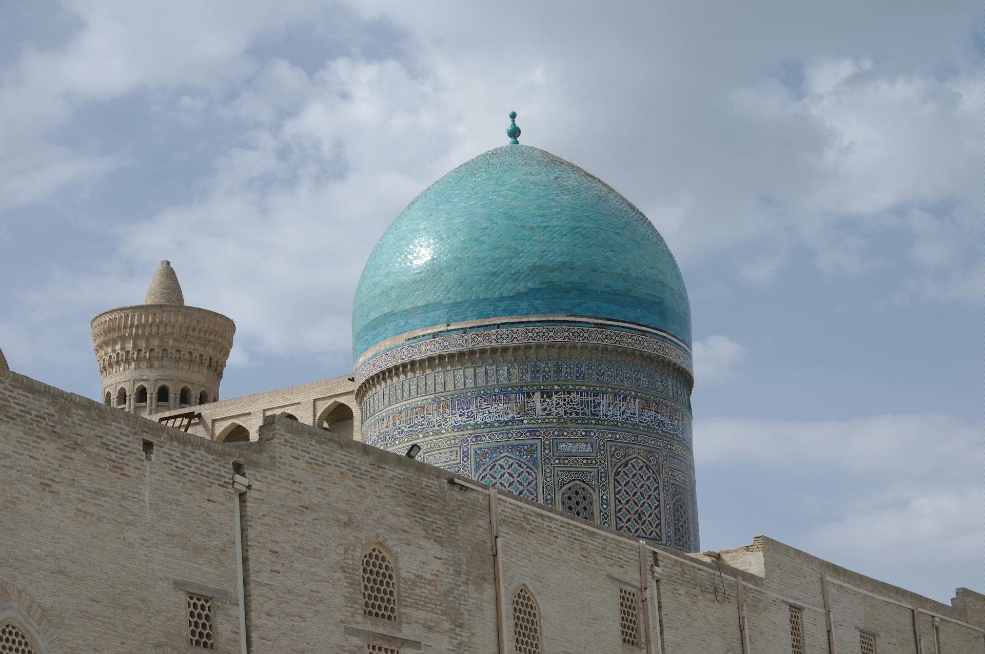 Stunning blue dome of a historic building in Boukhara, Uzbekistan against a cloudy sky.