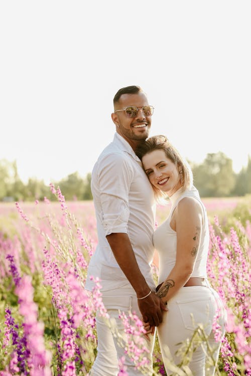 Happy couple hugging in field with flowers