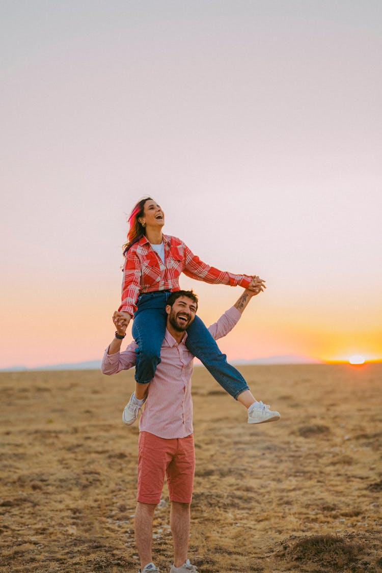 Happy Woman On Shoulders Of Man