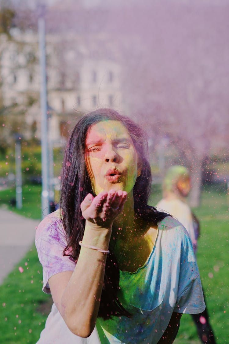 Woman Blowing Holi Powder From Her Hand