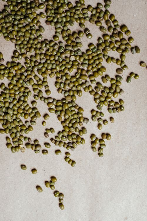 Free A close-up of mung beans scattered on a simple, neutral surface, embodying minimalism. Stock Photo