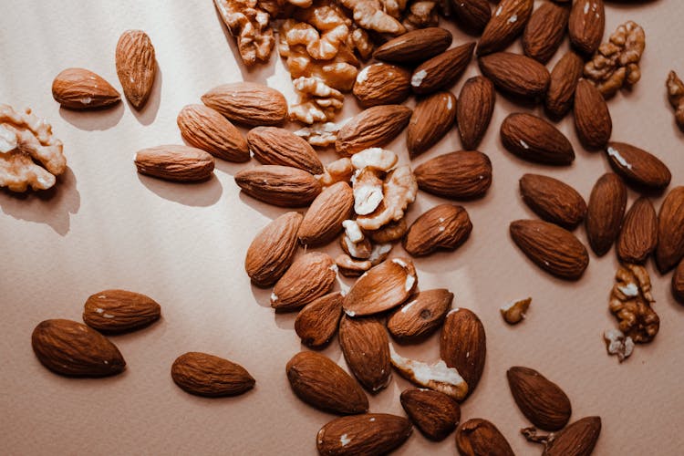 A Brown Almonds And Walnuts On A Flat Surface