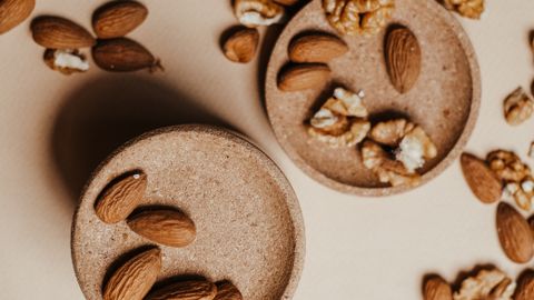High angle view of organic almonds and walnuts on beige background. Perfect for healthy lifestyle themes.