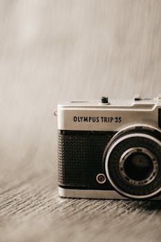 A classic Olympus Trip 35 camera with a retro design and textured finish in soft focus.