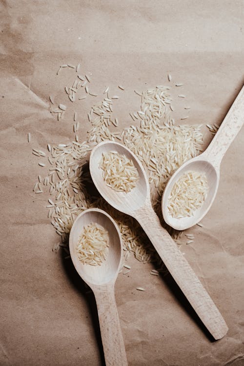 White Rice Grains on Wooden Spoons