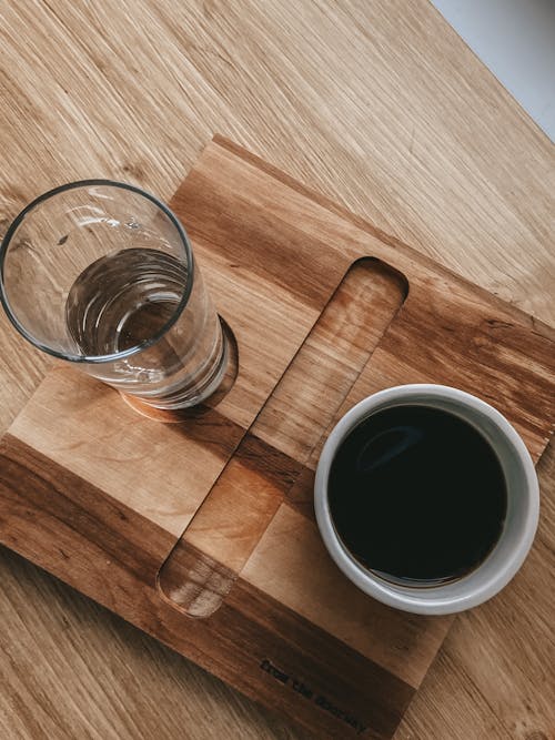 Free Top view of arrangement of cup of americano and glass of water served on wooden tray on table for making americano for breakfast Stock Photo