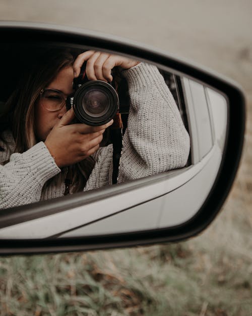 Woman taking photo of side mirror