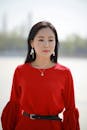 Woman in Red Crew Neck Long Sleeve Shirt Wearing Silver Necklace