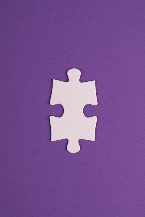 Free White Puzzle Piece on Purple Textile Stock Photo