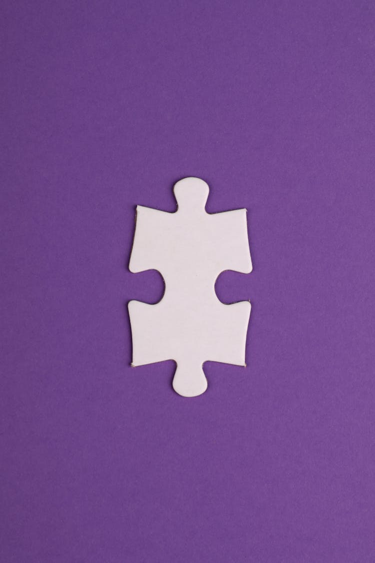 White Puzzle Piece On Purple Textile