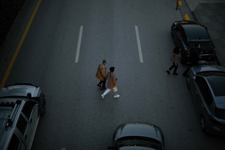 Couple Crossing The Asphalt Road