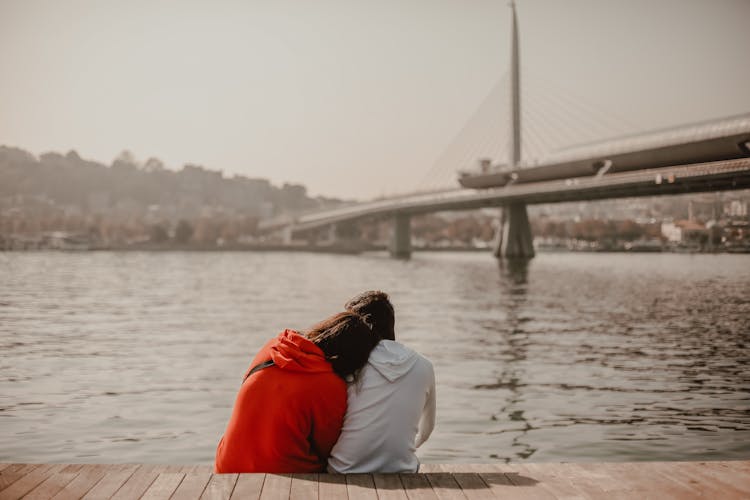 A Couple Sitting On The Docks