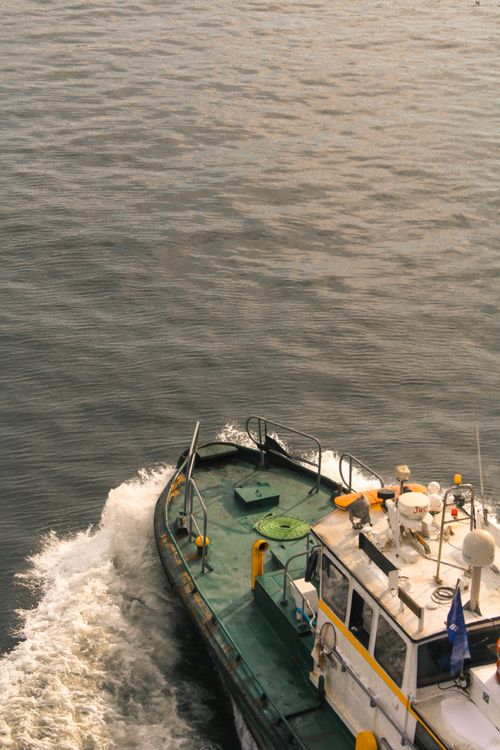 Free High-angle shot of a boat moving through the ocean with splashing water. Stock Photo