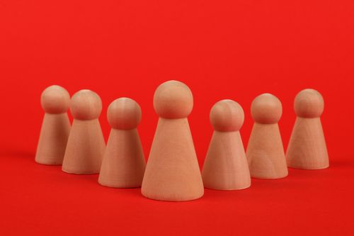 Free Close-up of crafted wooden figurines arranged on a vibrant red background. Stock Photo