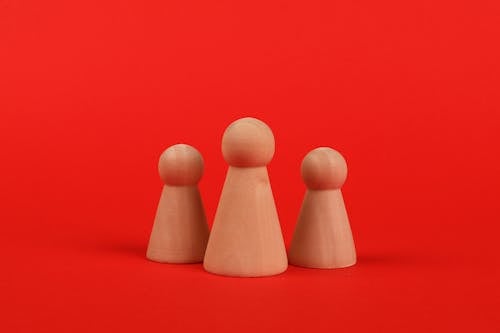 Brown Wooden Figures on the Red Surface