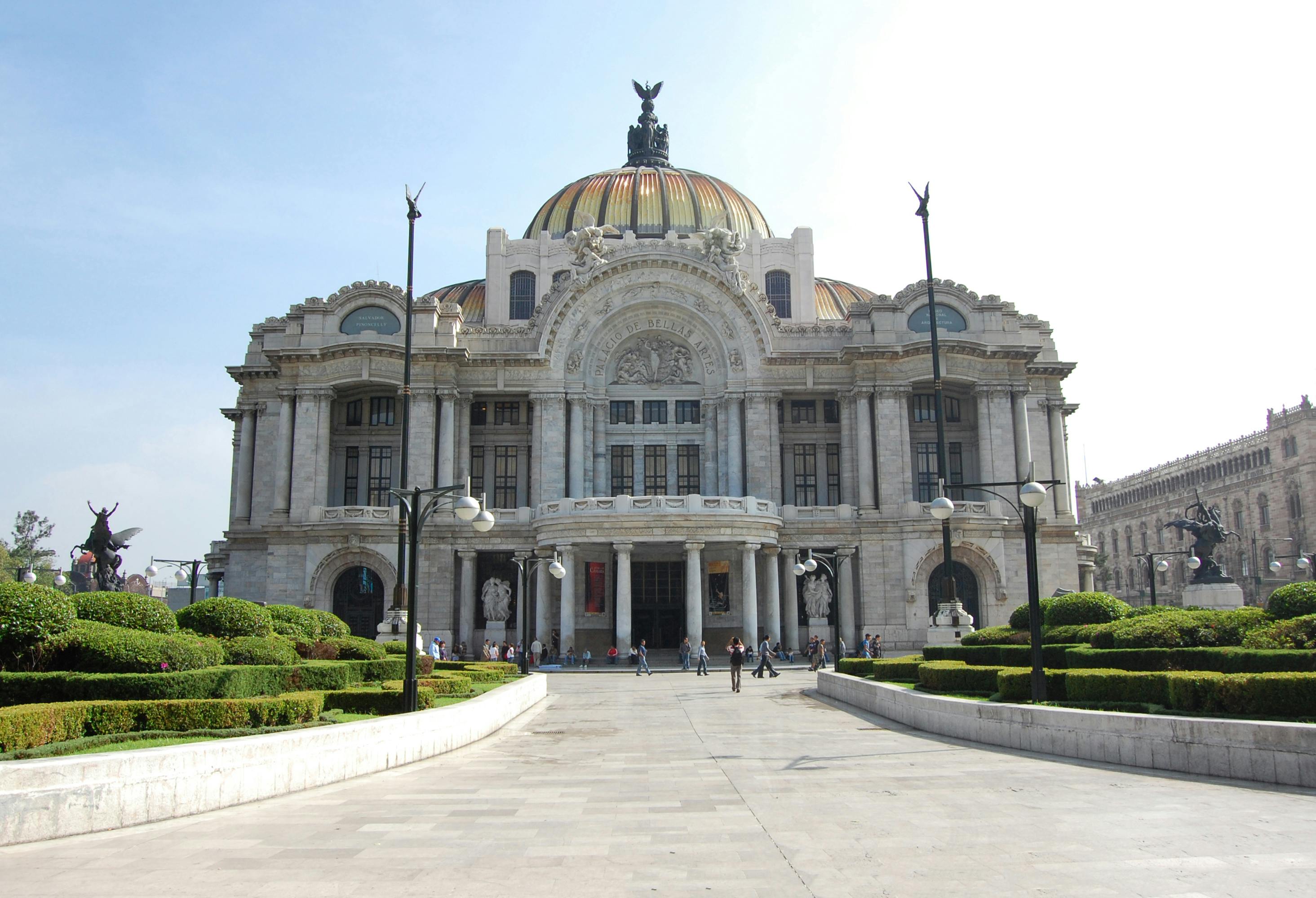 people walking in front of the palacio de bellas artes