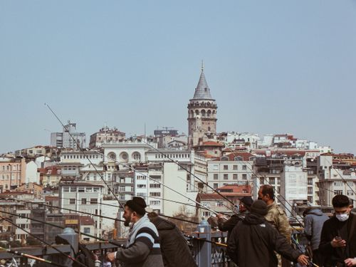 Free Scenic view of anglers fishing on Galata Bridge with Galata Tower and Istanbul's skyline in the background. Stock Photo