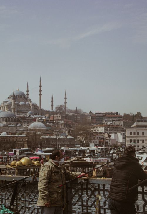 Free Fishermen at a bridge with a view of Istanbul's historic skyline, including the Blue Mosque. Stock Photo