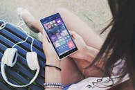 Woman Holding Turned Smartphone While Sitting on Bench Close-up Photography