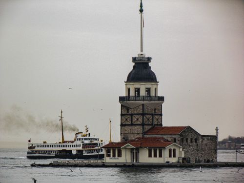Free Maiden's Tower with a ferry passing by on a cloudy day in Istanbul, Turkey. Stock Photo