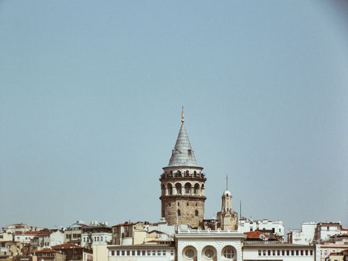 Free An iconic view of Galata Tower rising above the historic buildings of Istanbul under a clear blue sky. Stock Photo