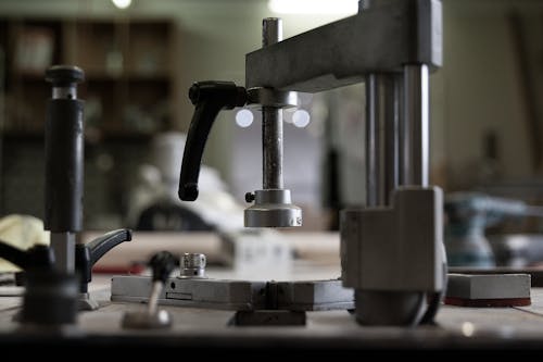 Soft focus of weathered part of industrial machinery installed on workbench in professional workshop