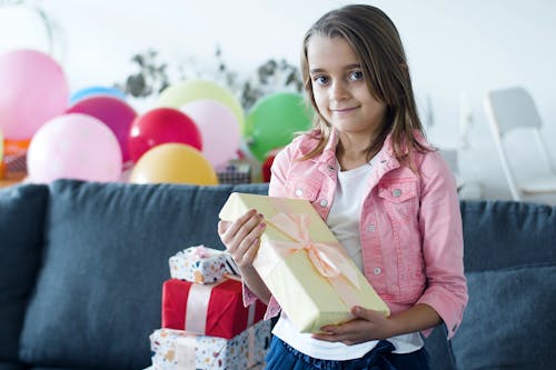 Free Girl in Pink Jacket Holding a Gift Stock Photo