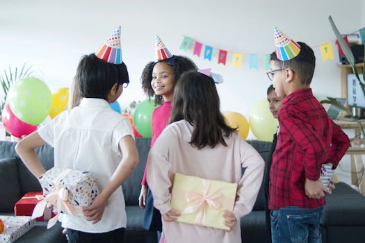 Children celebrating a birthday with gifts and colorful decorations indoors.